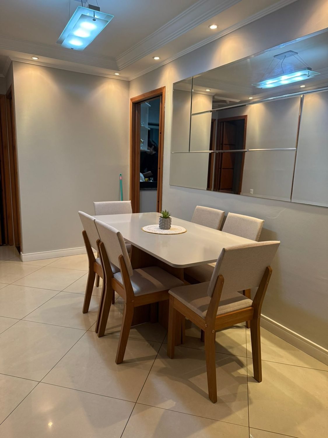 Mesa de jantar montada com cadeiras em apartamento