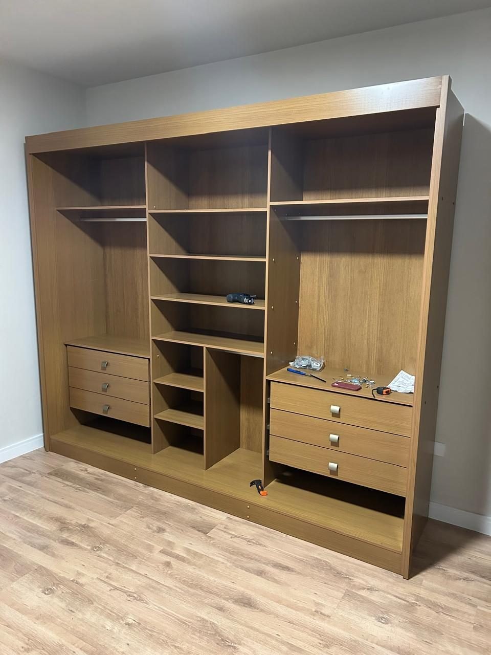 Guarda-roupa aberto em montagem com divisorias, gavetas e cabideiros alinhados