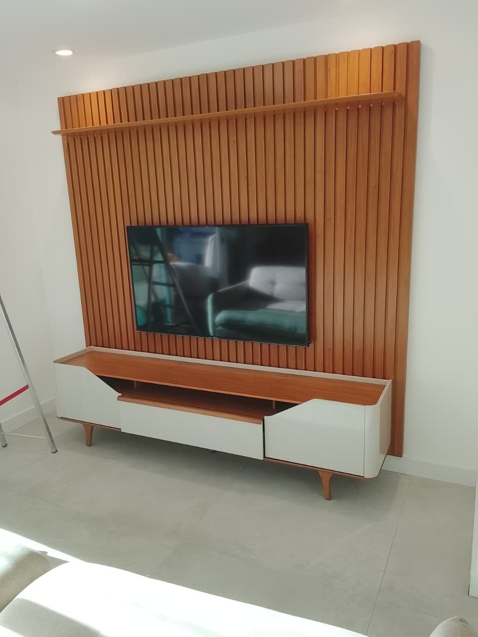 Painel ripado de TV instalado em sala clara